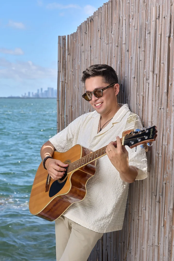 Lucas Álvarez tocando la guitarra para una sesion de fotos de Imagen Miami