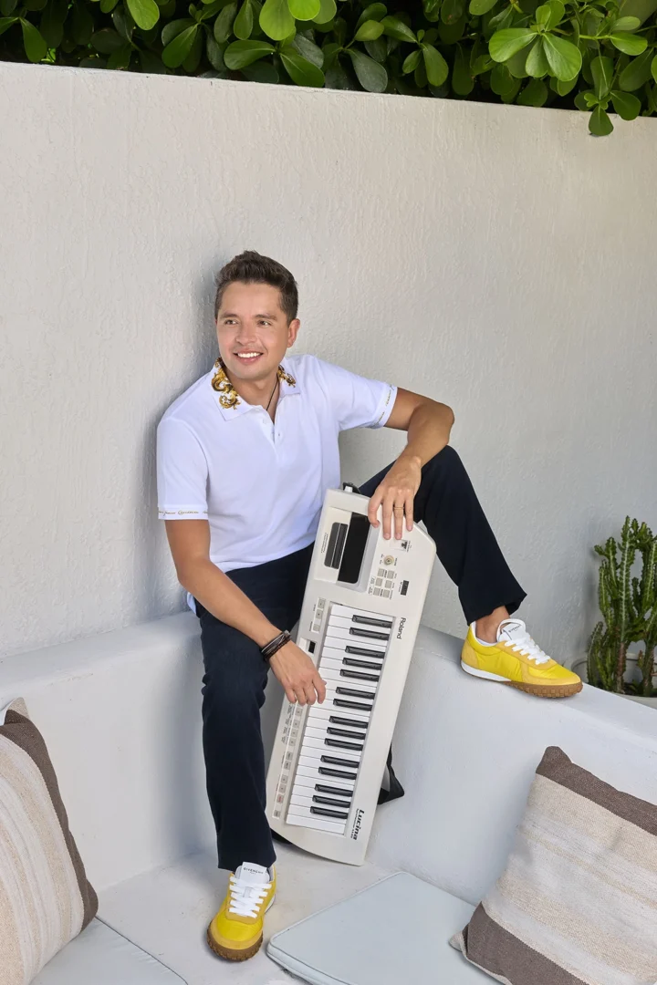 Lucas Álvarez junto a un piano en una sesion de fotos para Imagen Miami